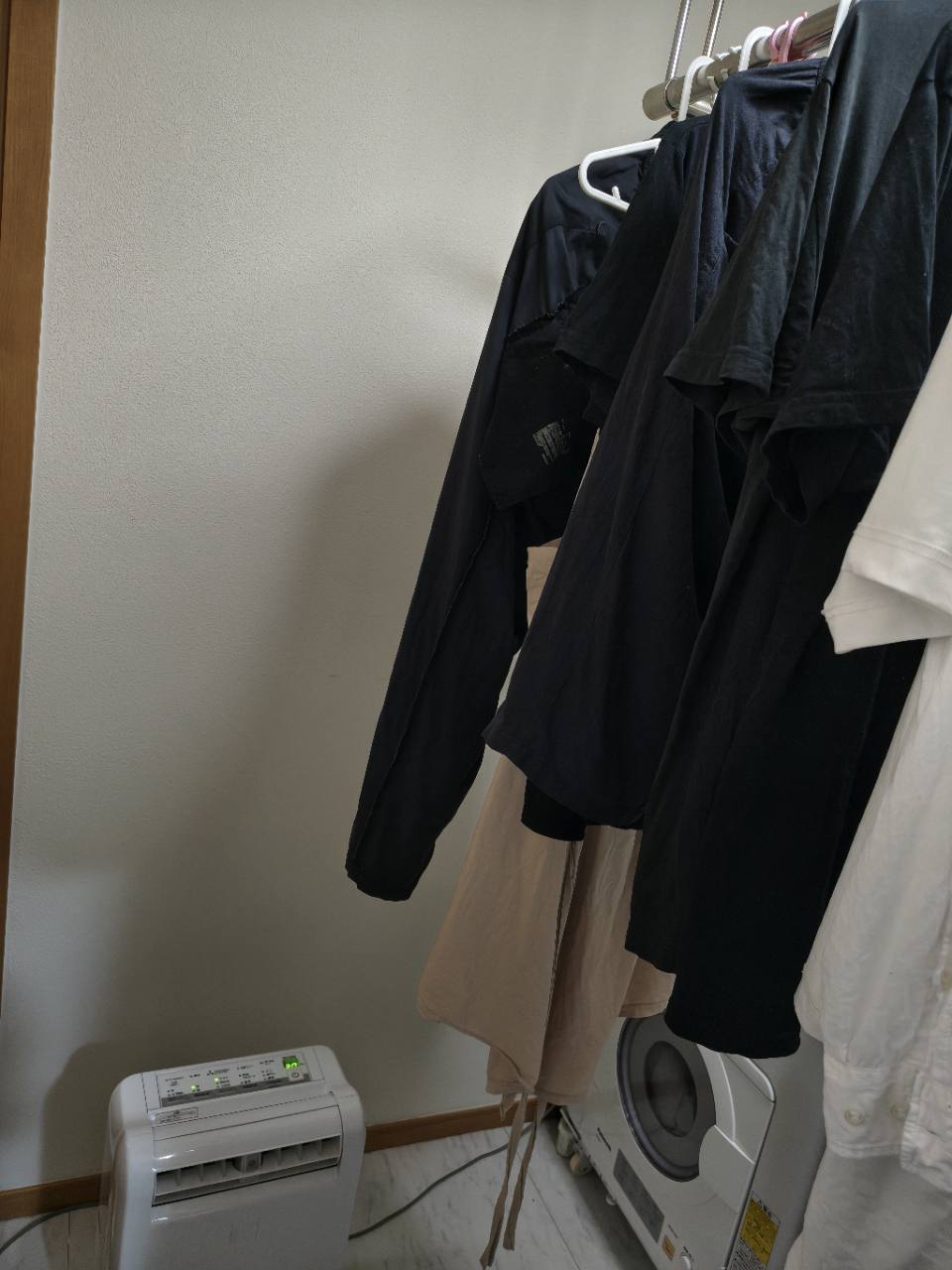 部屋干しの衣類の下の三菱除湿機と隣の衣類乾燥機